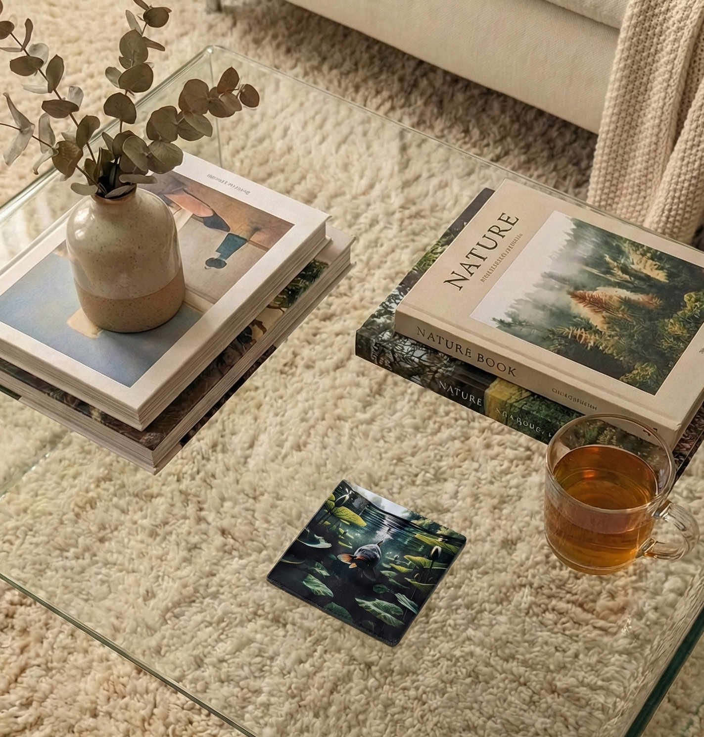 A square coaster displays a dark carp surrounded by submerged green foliage and lily pads. The background is a soft, shaggy beige rug.