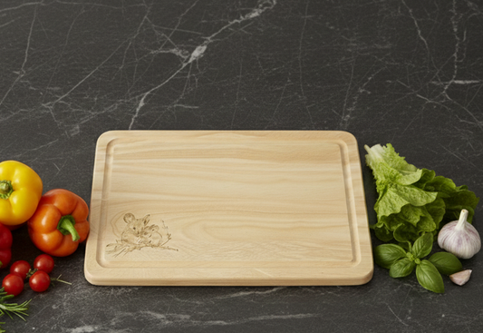 Light wood cutting board with rounded edges and mouse engraving, placed on a dark Grey marbled countertop.