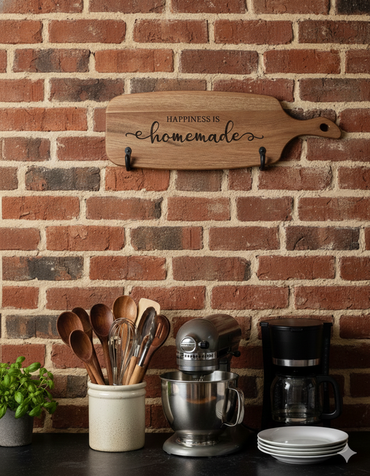 Rustic wooden serving board, inscribed "Happiness is homemade," hanging on a textured red-brown brick wall above kitchen appliances.