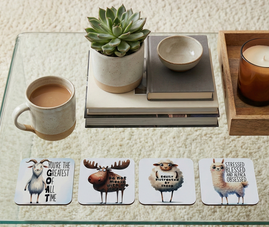 Four coasters with animal cartoons on a glass table with a green succulent and cream ceramic mug on a shag rug.