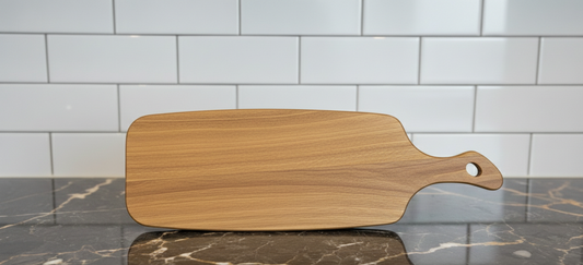 Smooth, light brown wooden cutting board on a dark, reflective marble countertop, contrasting with white tiled backsplash.