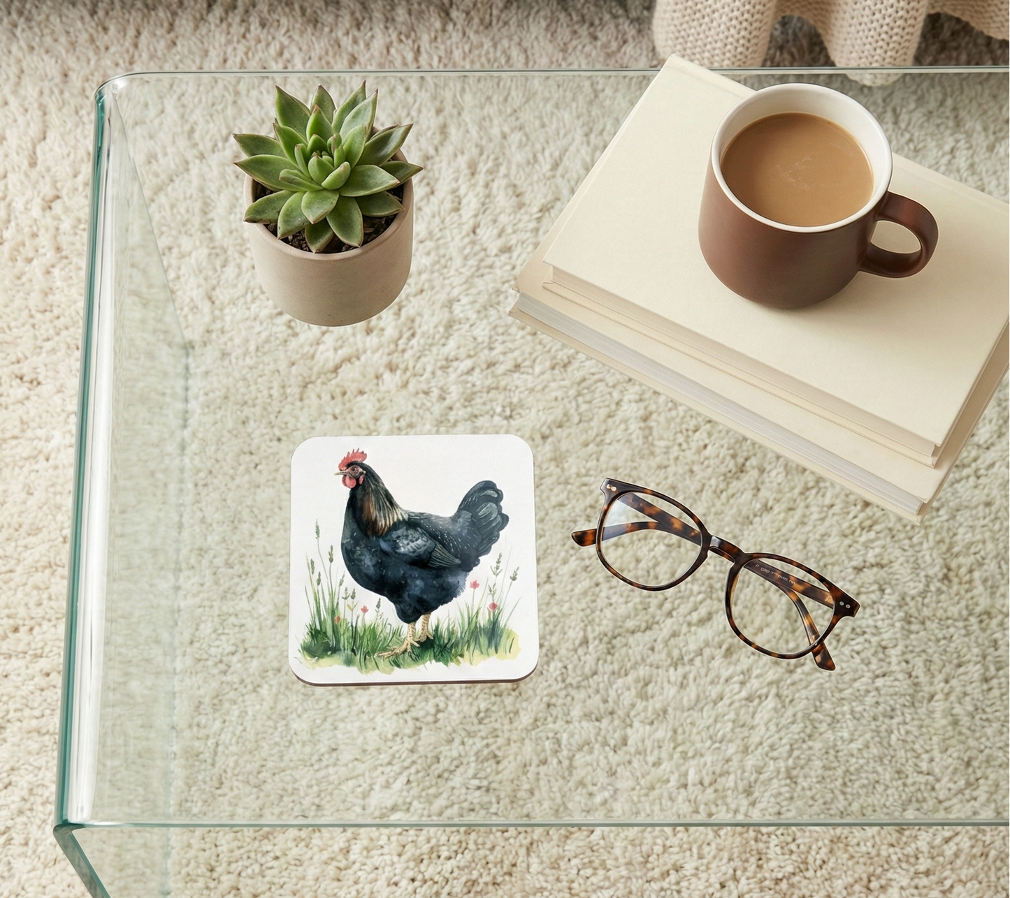 Close-up shot of a square coaster featuring a glossy black chicken illustration standing in lush green grass.