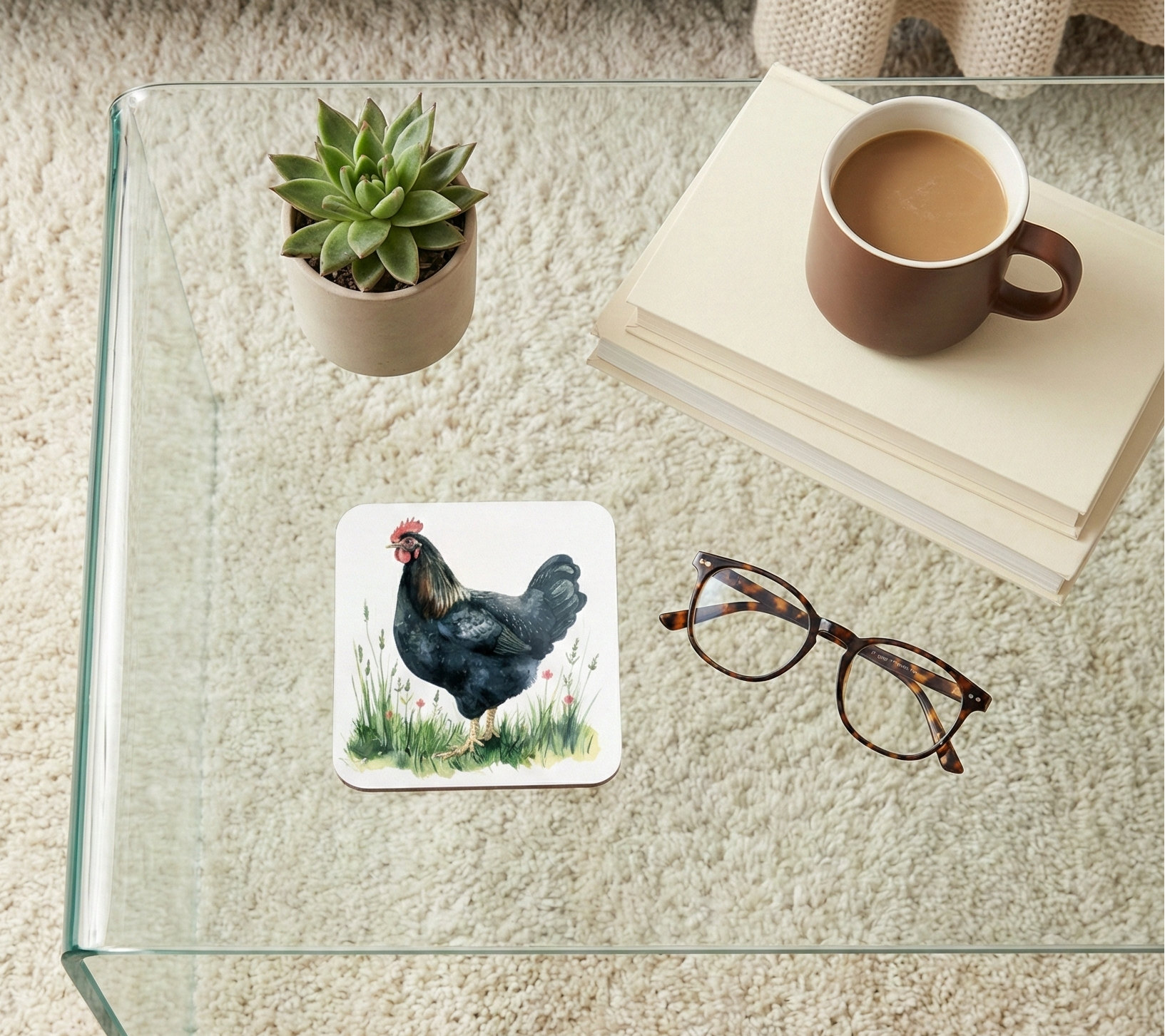 Close-up shot of a square coaster featuring a glossy black chicken illustration standing in lush green grass.