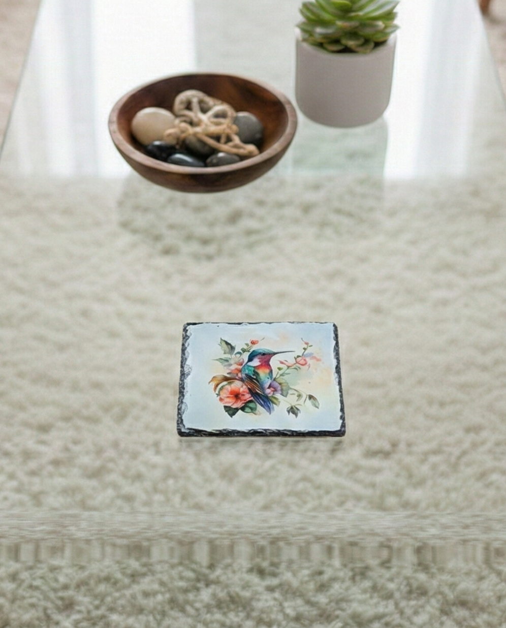 Square slate coaster displaying a vibrant red and teal watercolour hummingbird design. The coaster edge is rugged, natural slate.