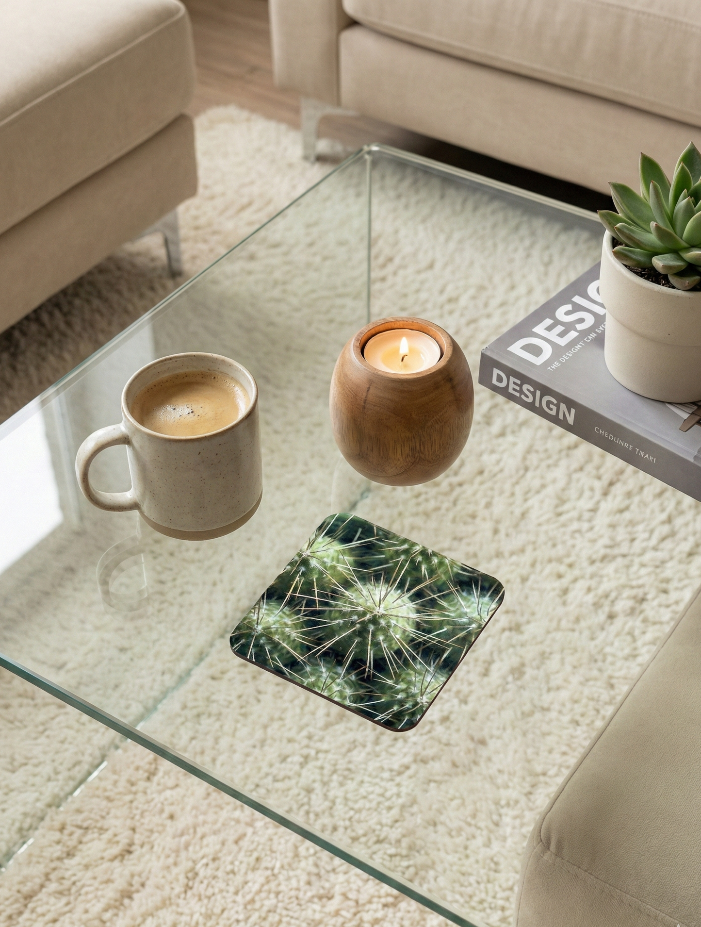 A square coaster displays a radial pattern of light-green cactus spines. Nearby are a stone mug and a burning wooden candle.
