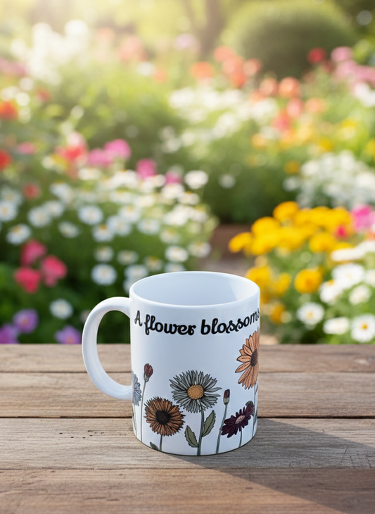White ceramic mug with muted retro floral illustrations and text, resting on wooden planks in a bright, blurry garden.